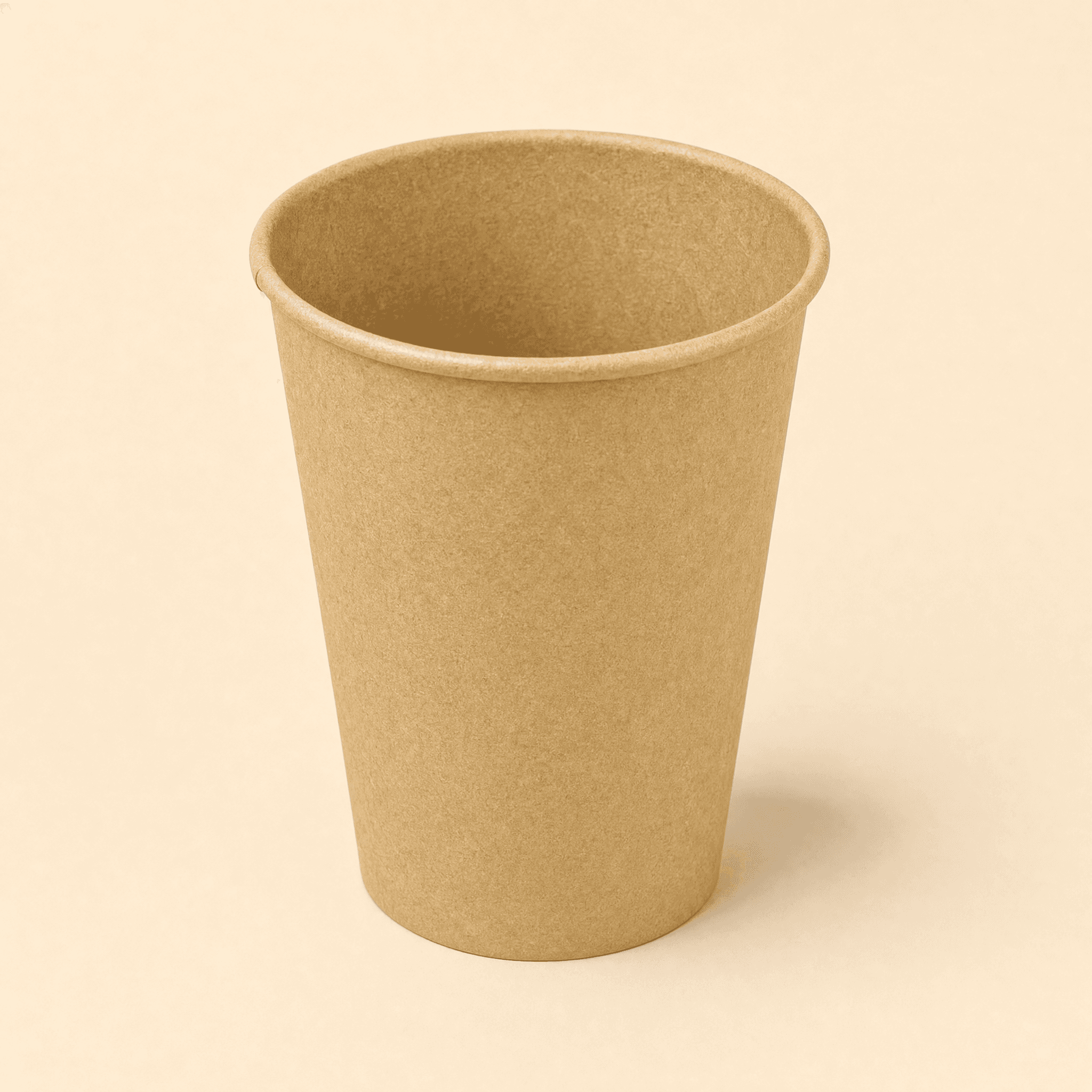 12 oz plain kraft brown single-wall paper hot cup at a three-quarter angle on a cream studio background, showing the rolled rim and tapered body