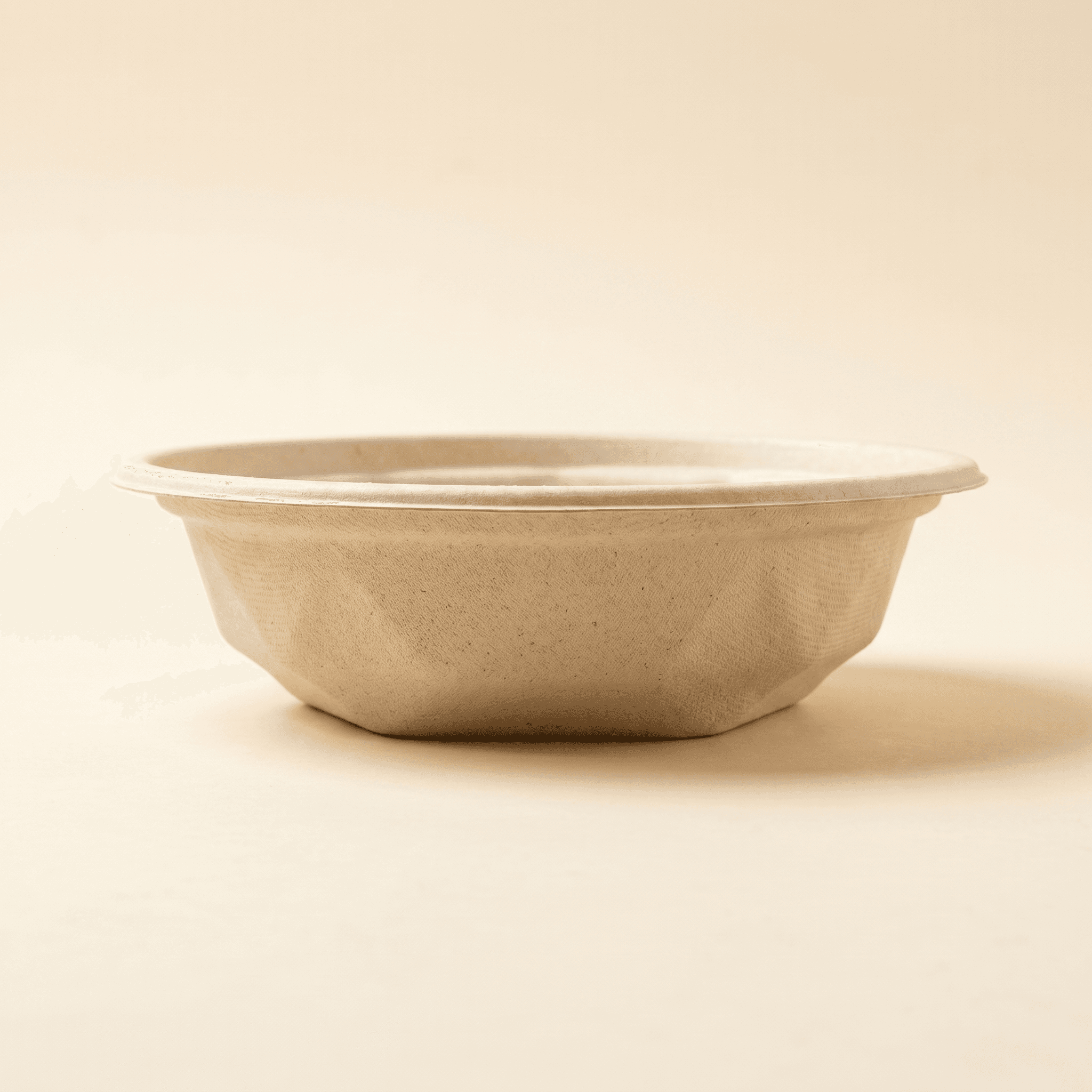 Eye-level side profile of the empty bowl showing the wide flat rolled rim and the faceted lower sidewall stepping down to the foot