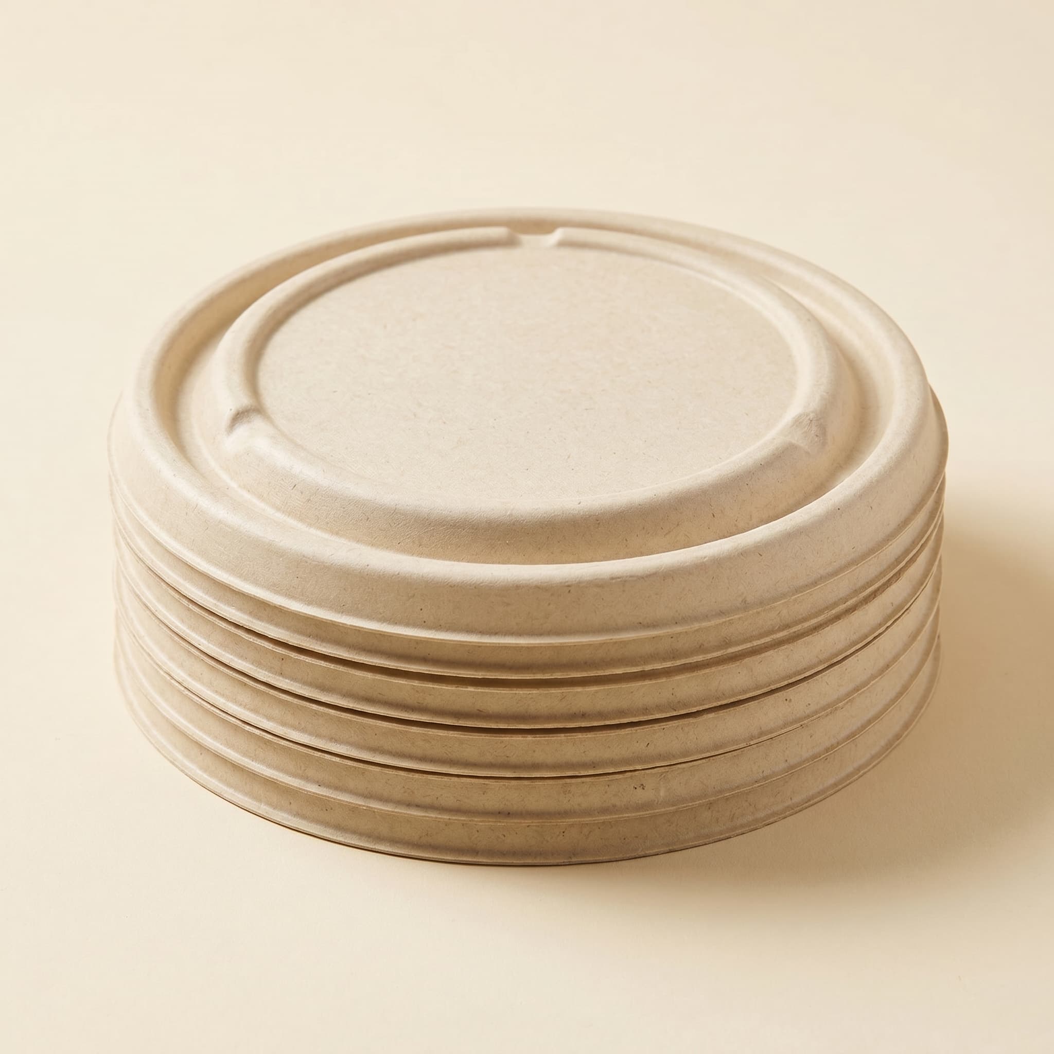 A neat stack of bagasse fiber lids nested compactly together, showing how they store