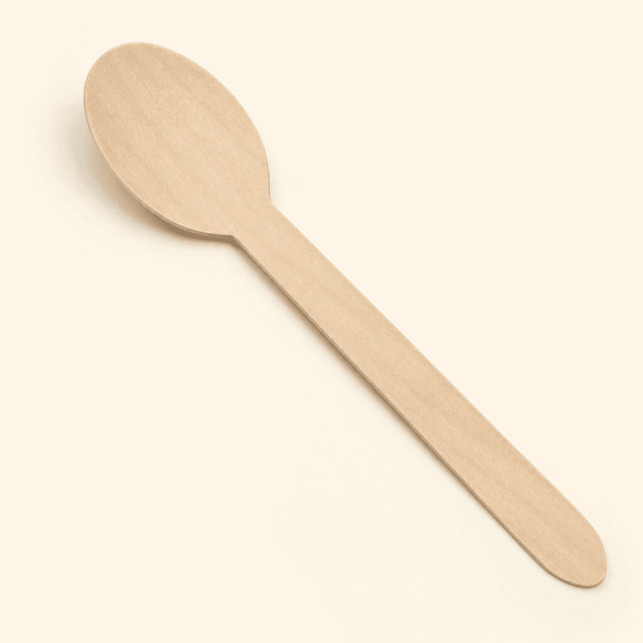 Single birch wood spoon at a three-quarter angle on a cream studio background, showing the oval bowl and flat tapered handle